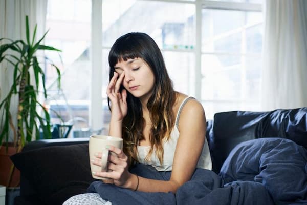 Femme fatiguée au réveil près d'une fenêtre